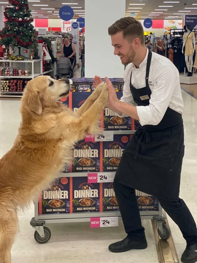 Jake Lylia Cooklylia chef in apron having fun with his dog
